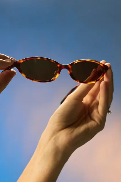Sunglasses held up against the sky