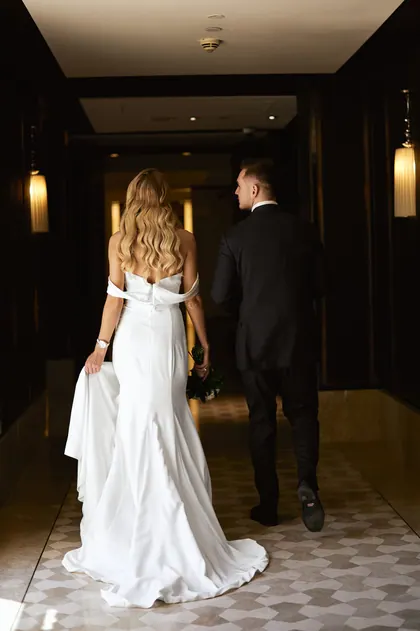 Bride and groom walking down a hotel corridor
